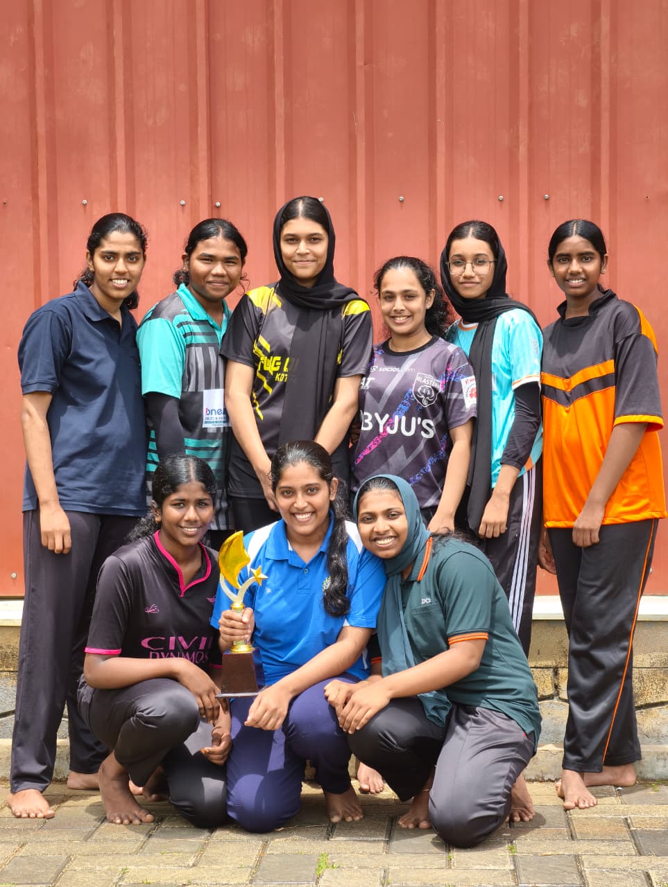 Sports team achievement - Students with trophy celebrating victory
